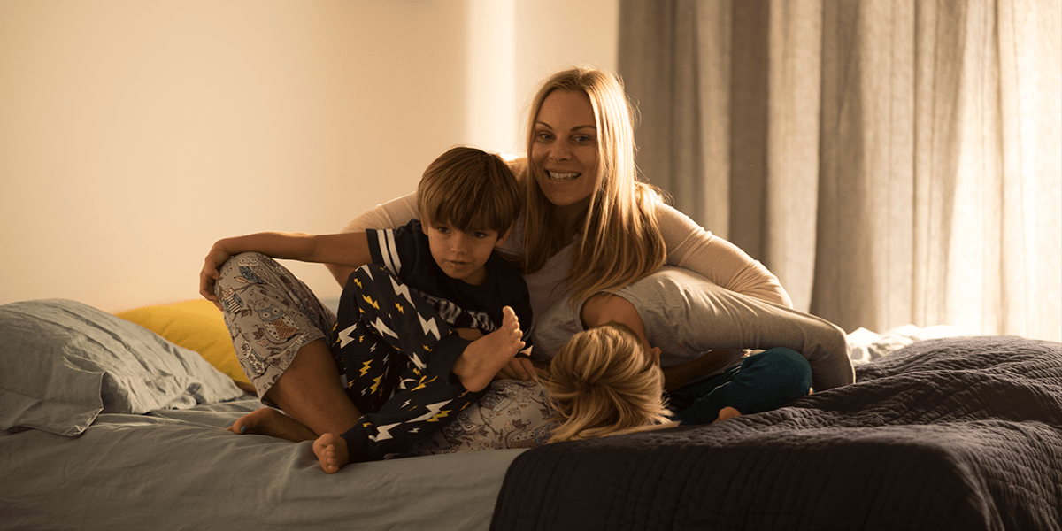 Mutter mit zwei Kindern auf dem Bett
