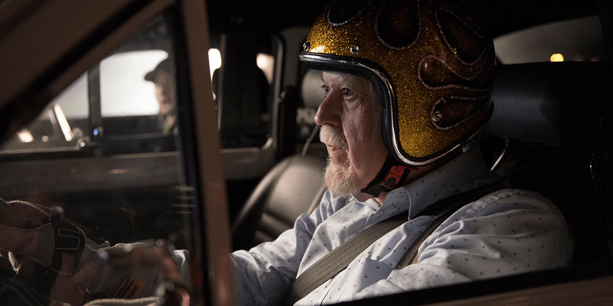Älterer Mann mit Helm sitzt in einem Fahrzeug