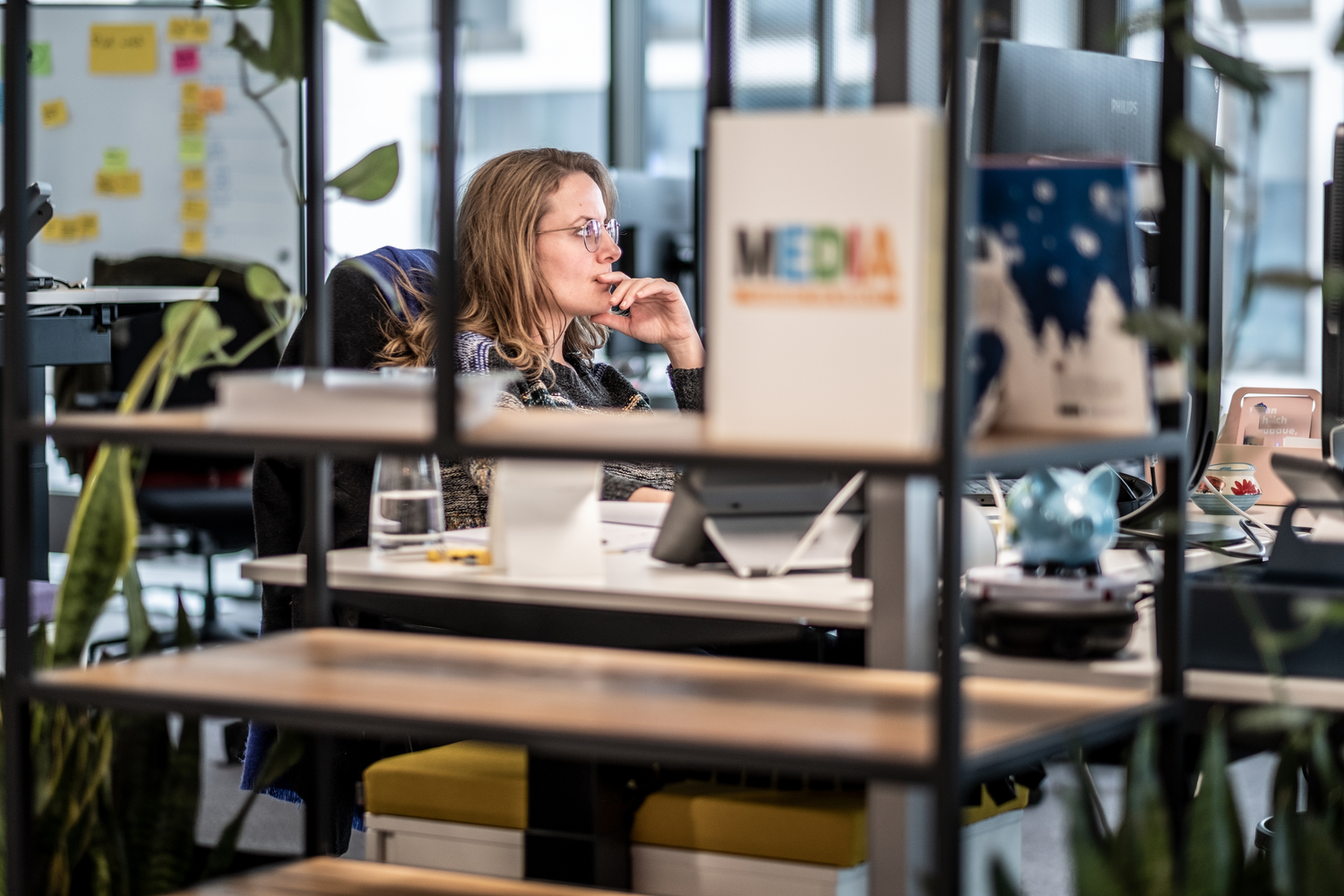 Frau in einem modernen Büro schaut nachdenklich.