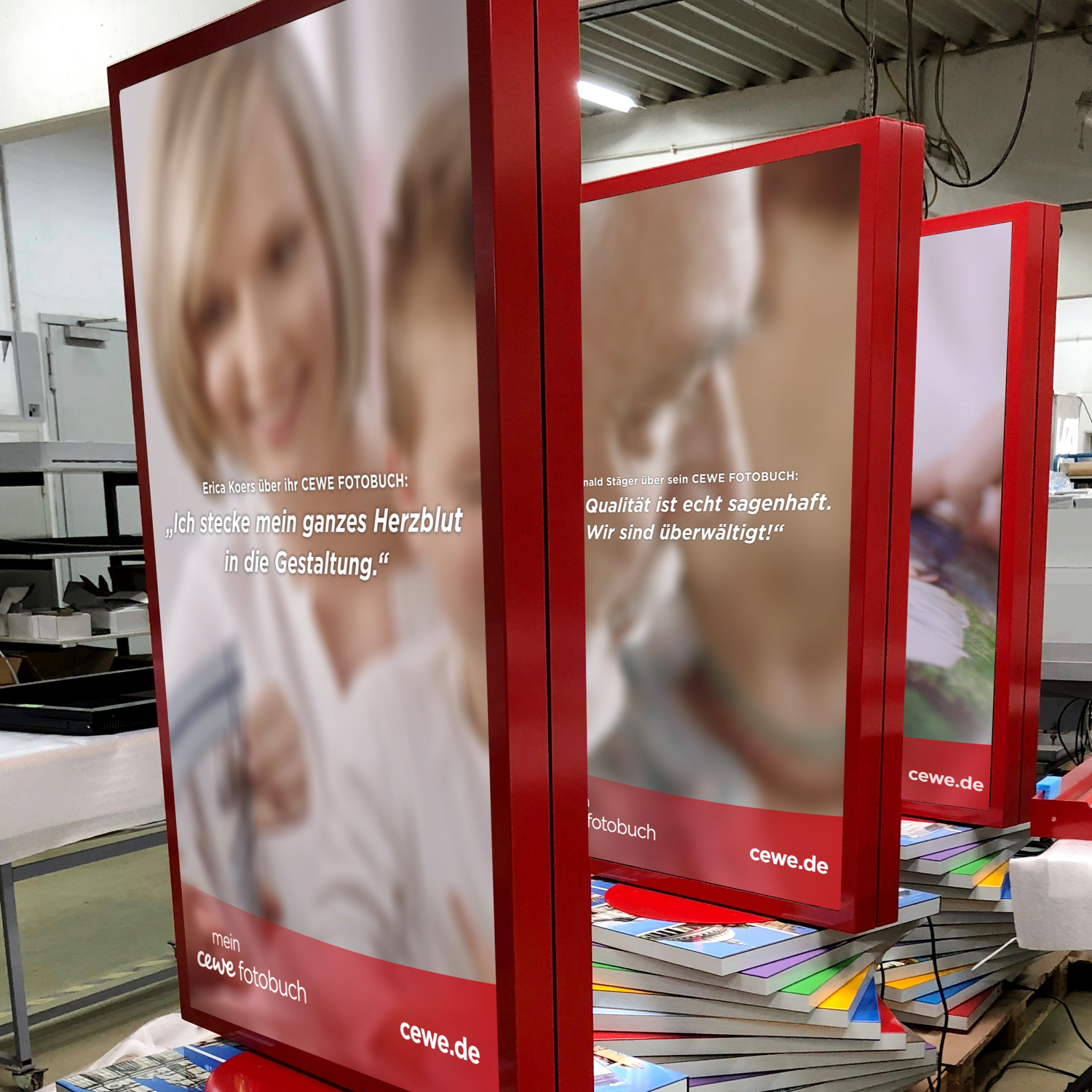 Mehrere CEWE-Werbeplakate in einer Produktionsumgebung.