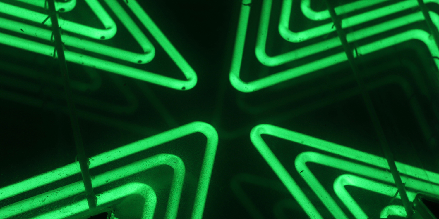 Grüne Neonlichter in Pfeilform.