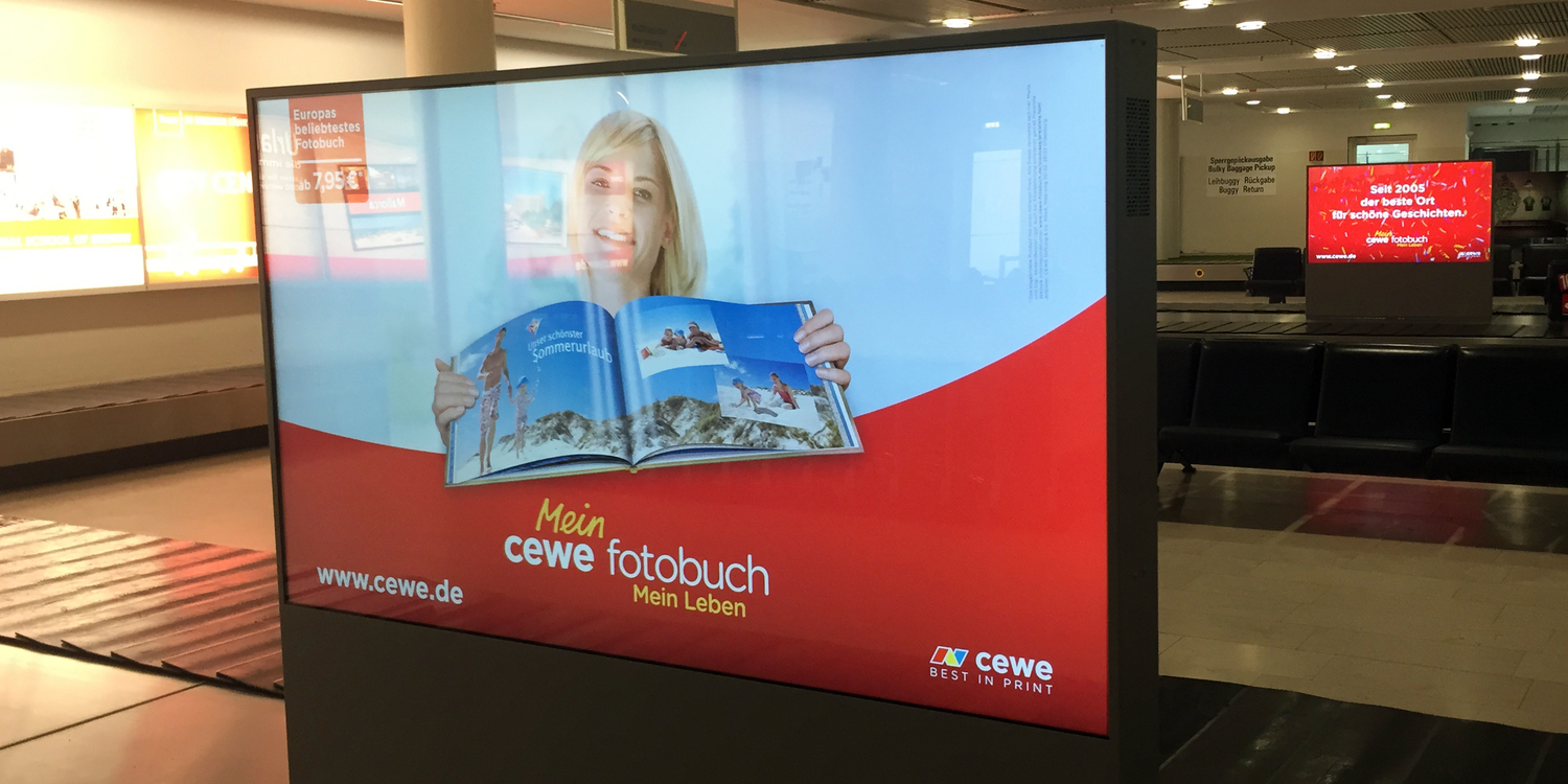 Digitale Werbetafel mit CEWE-Fotobuch-Werbung.