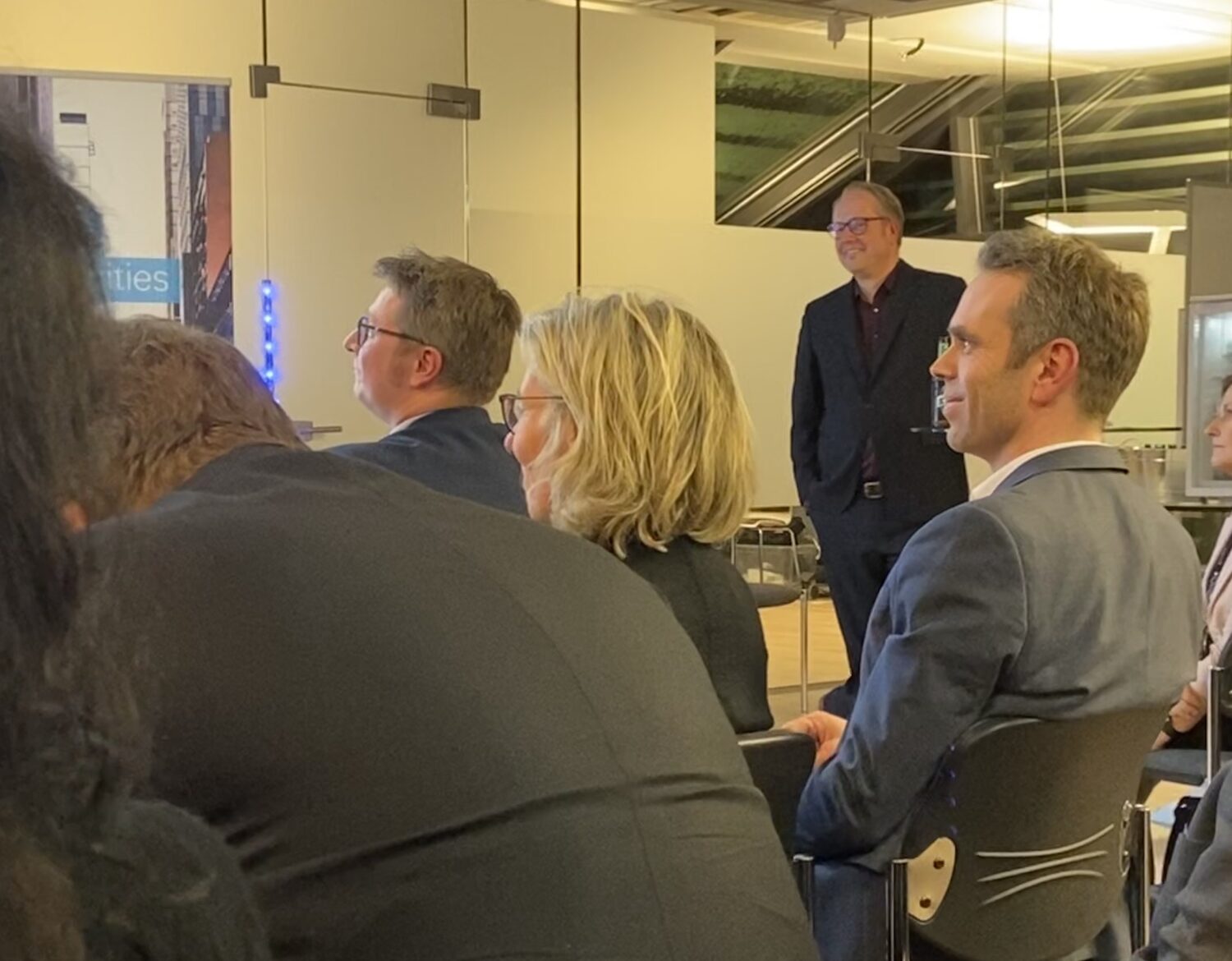 Publikum sitzt und hört aufmerksam einer Präsentation zu.