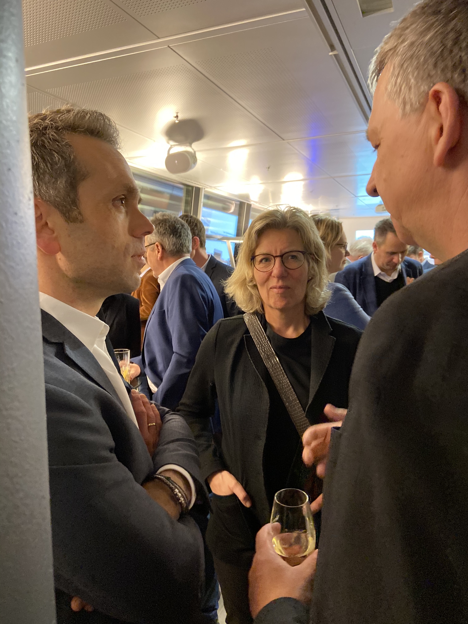 Drei Personen in vertieftem Gespräch während eines Networking-Events.