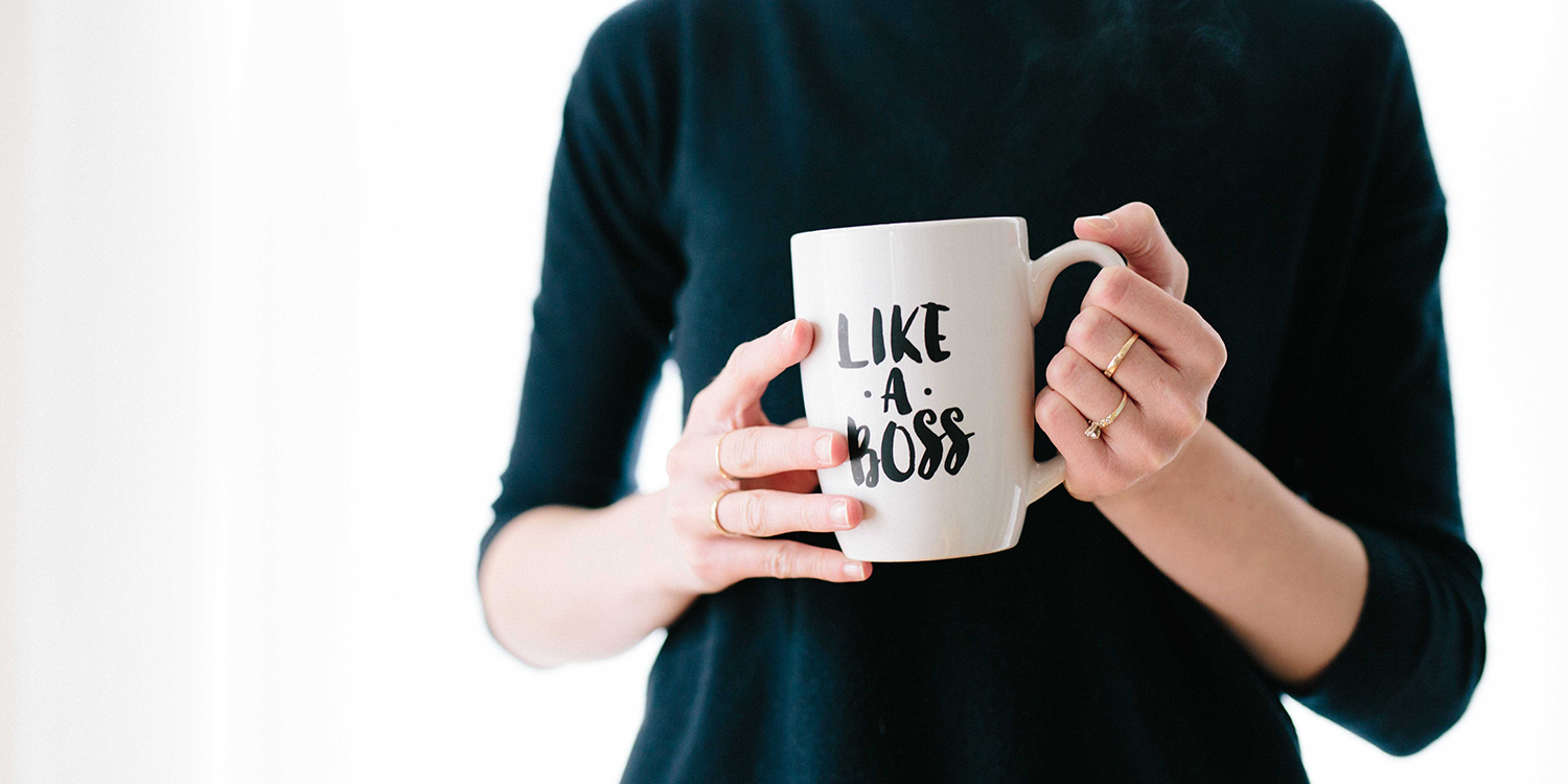 Frau hält eine Tasse mit der Aufschrift 