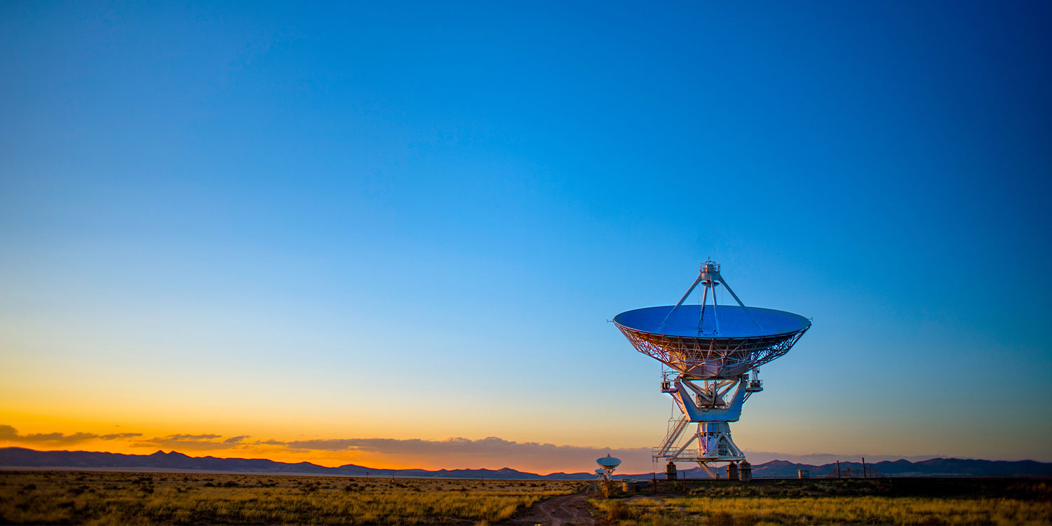 Satellitenschüssel vor einem Sonnenuntergang.