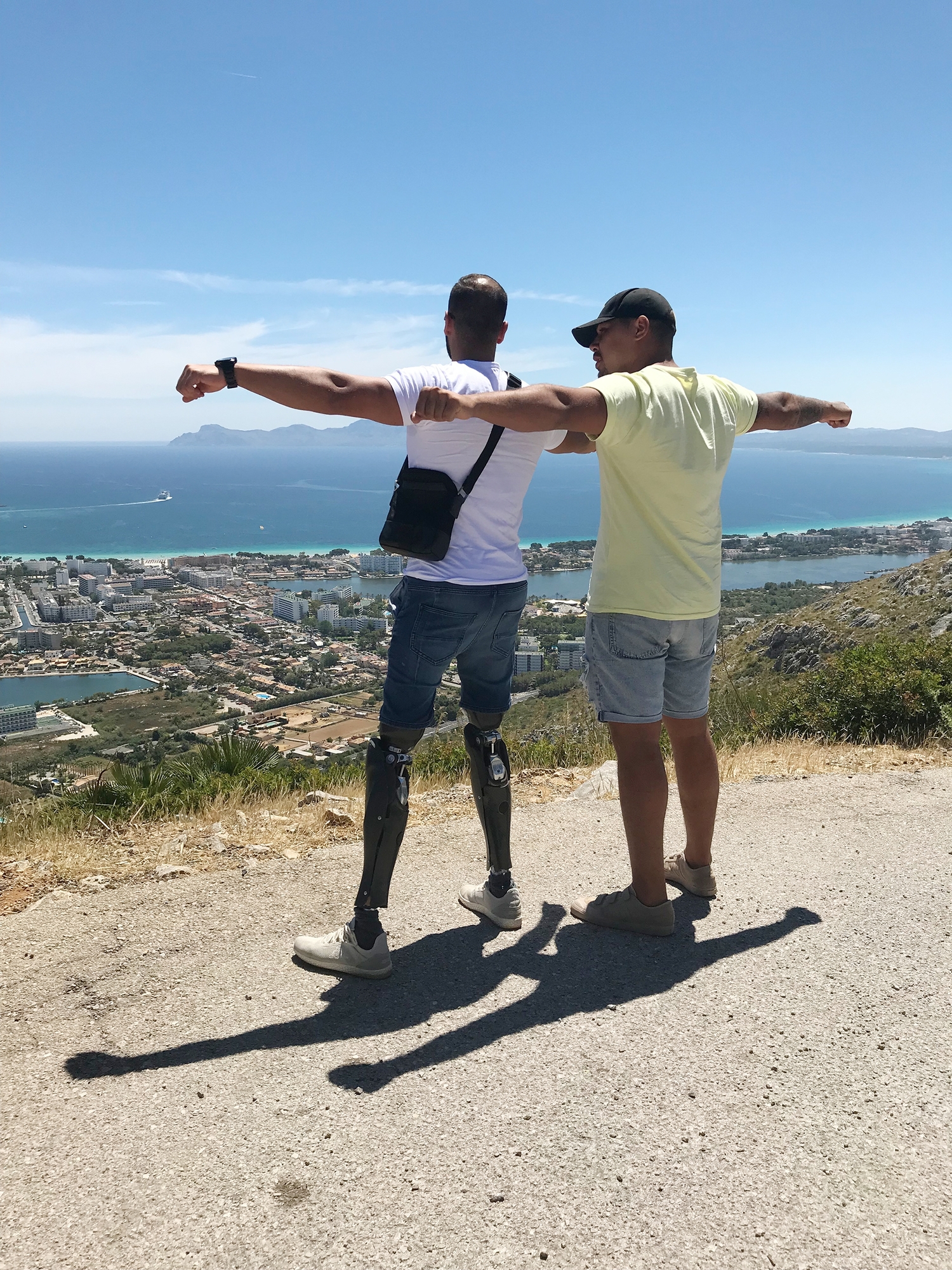 Freunde stehen mit ausgestreckten Armen am Strand.