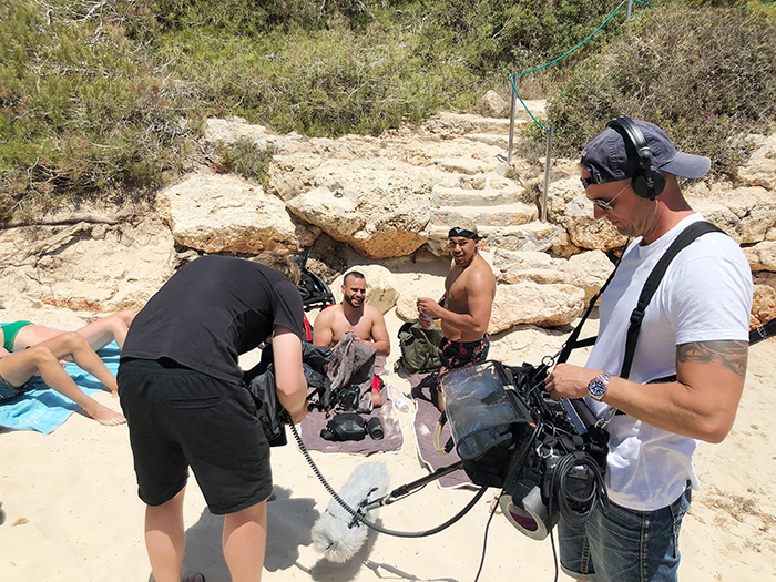 Eine Filmcrew bei der Arbeit am Strand.