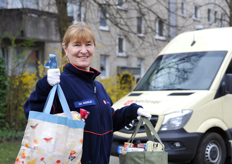 Lächelnde Frau vor einem Rettungswagen.