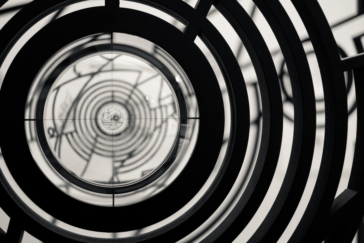 Schwarz-weißes, spiralförmiges, abstraktes Muster.