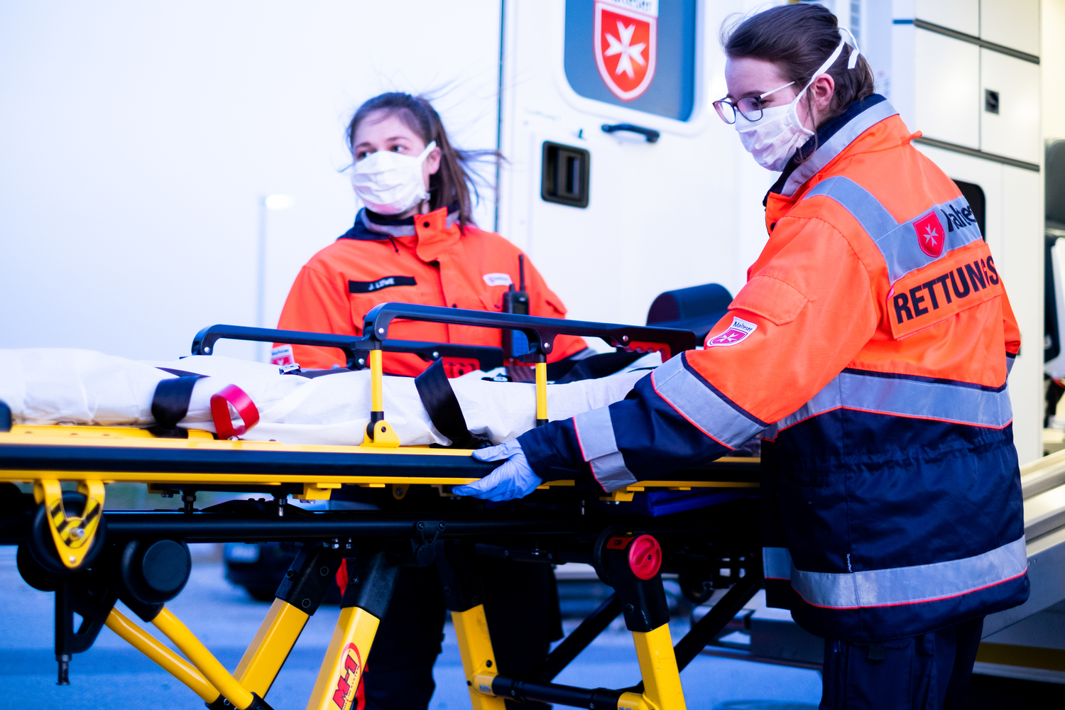 Sanitäter in Uniform schieben eine Trage.