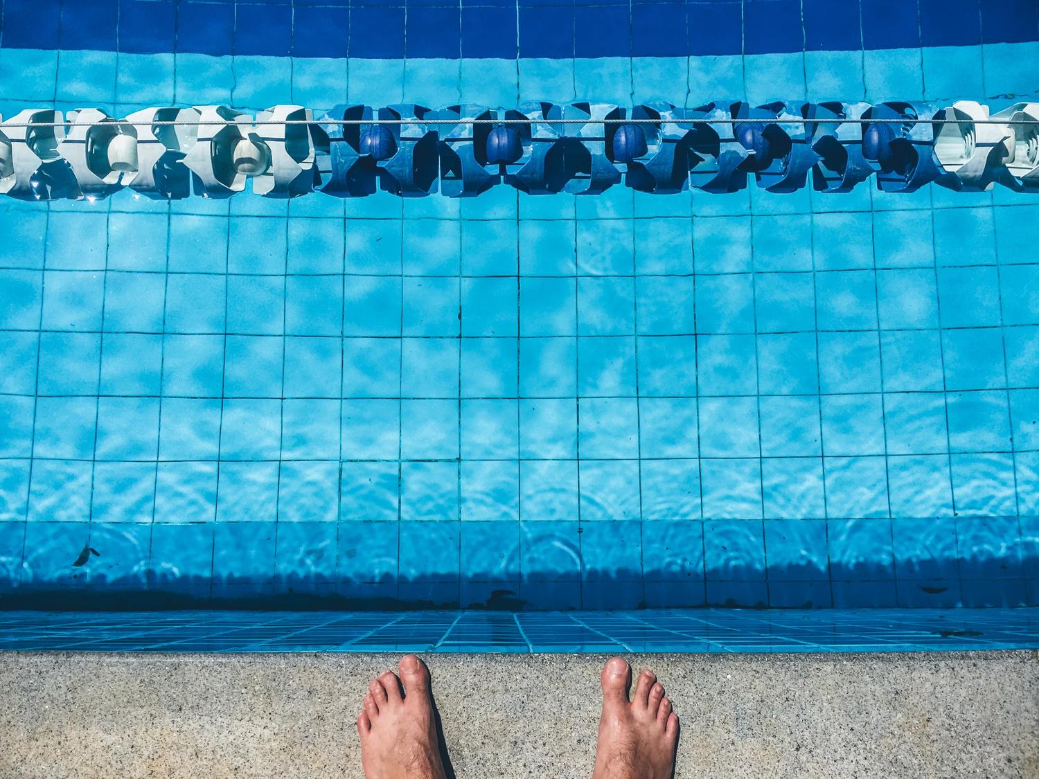 Eine Person steht am Rand eines Schwimmingpools.