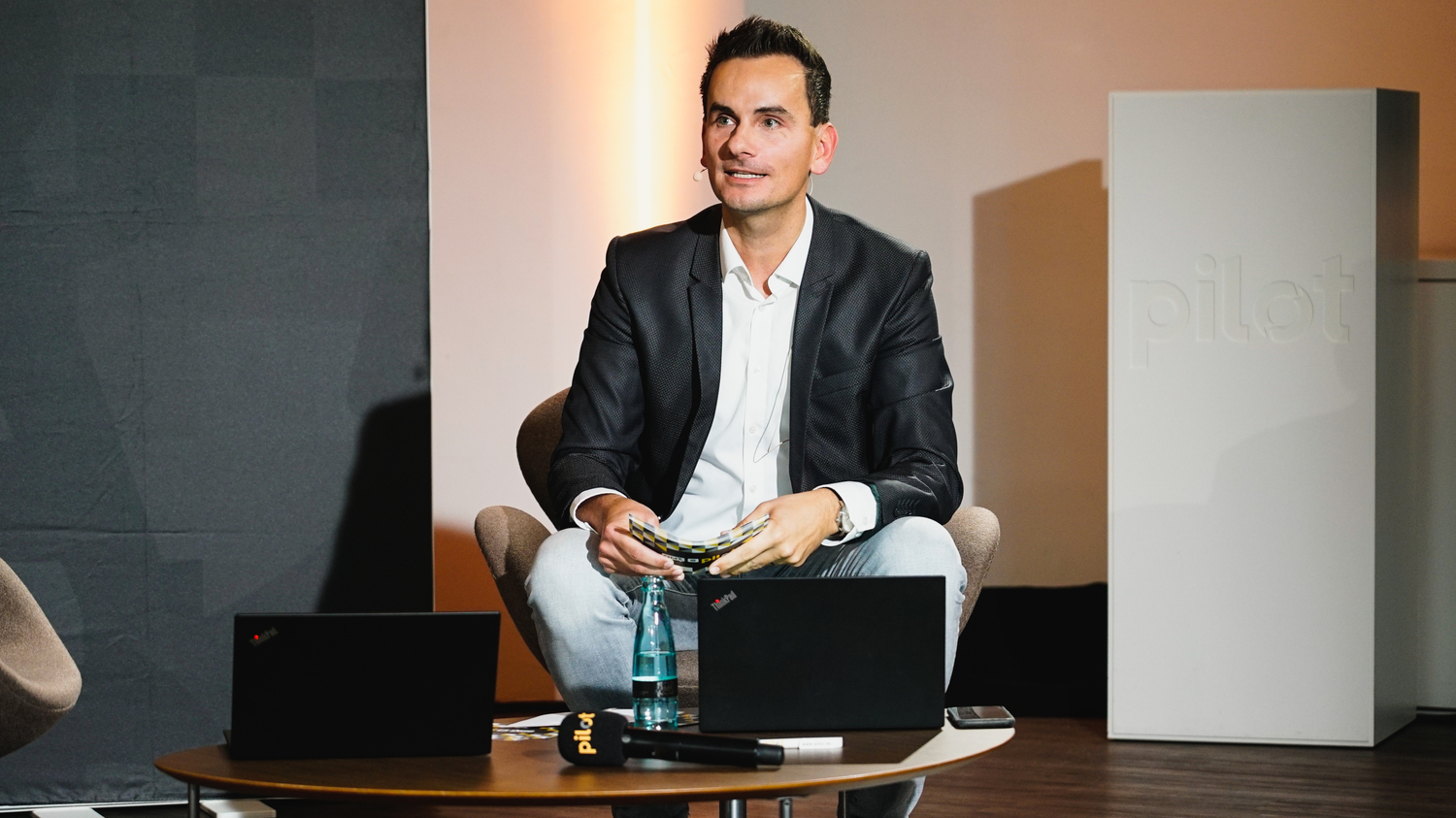 Moderator mit Laptop auf der Bühne
