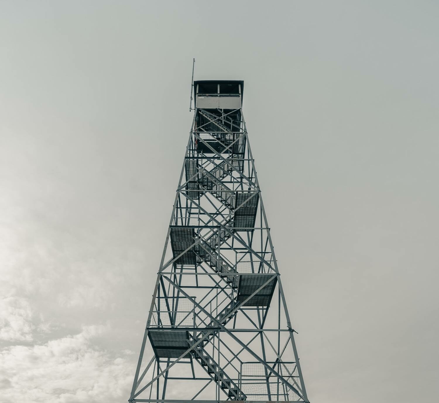 Ein Turm vor grauem Himmel.