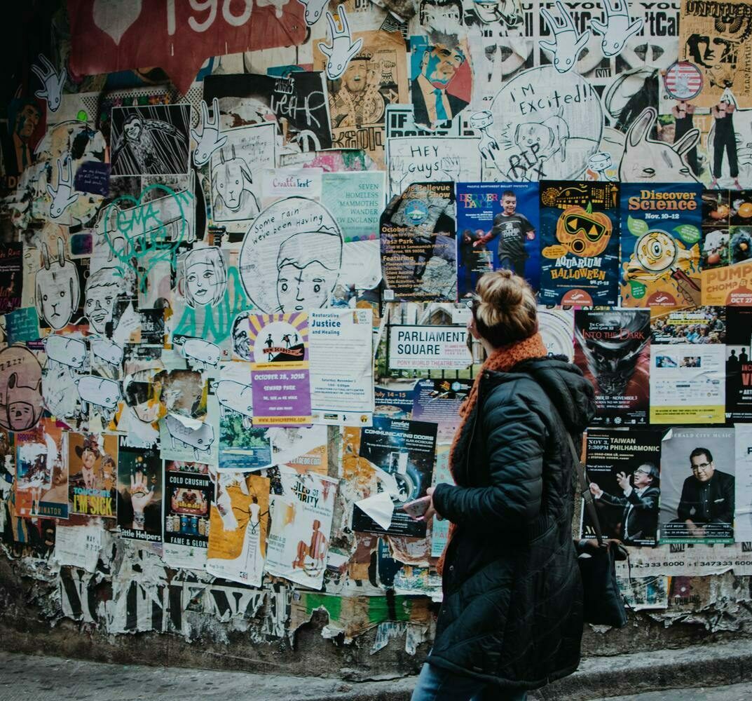 Eine Wand voller Plakate und Graffiti.