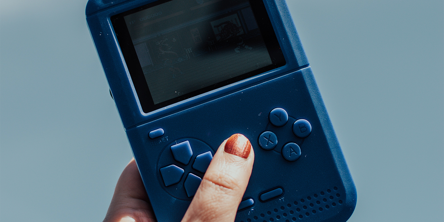 Hand hält einen blauen Game Boy.