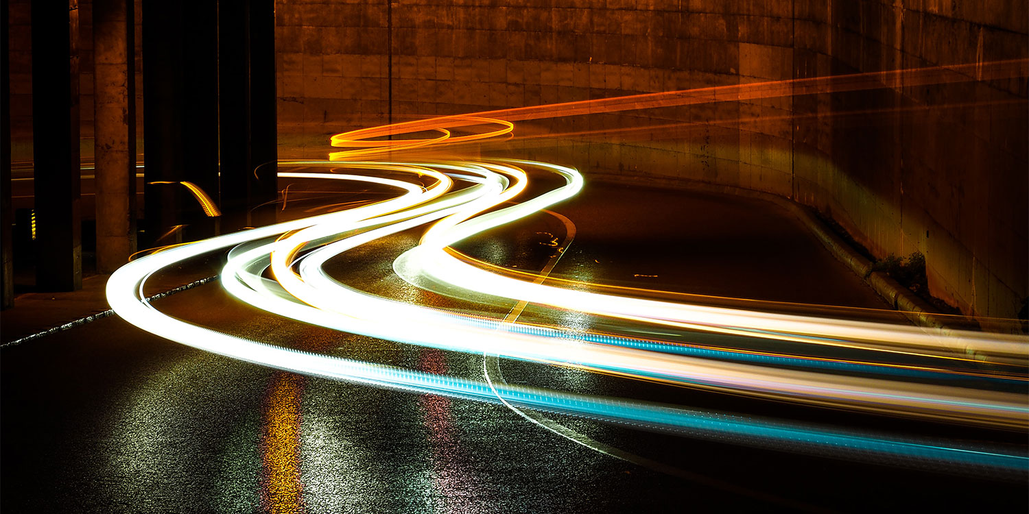 Lichtspuren auf einer nächtlichen Straße.