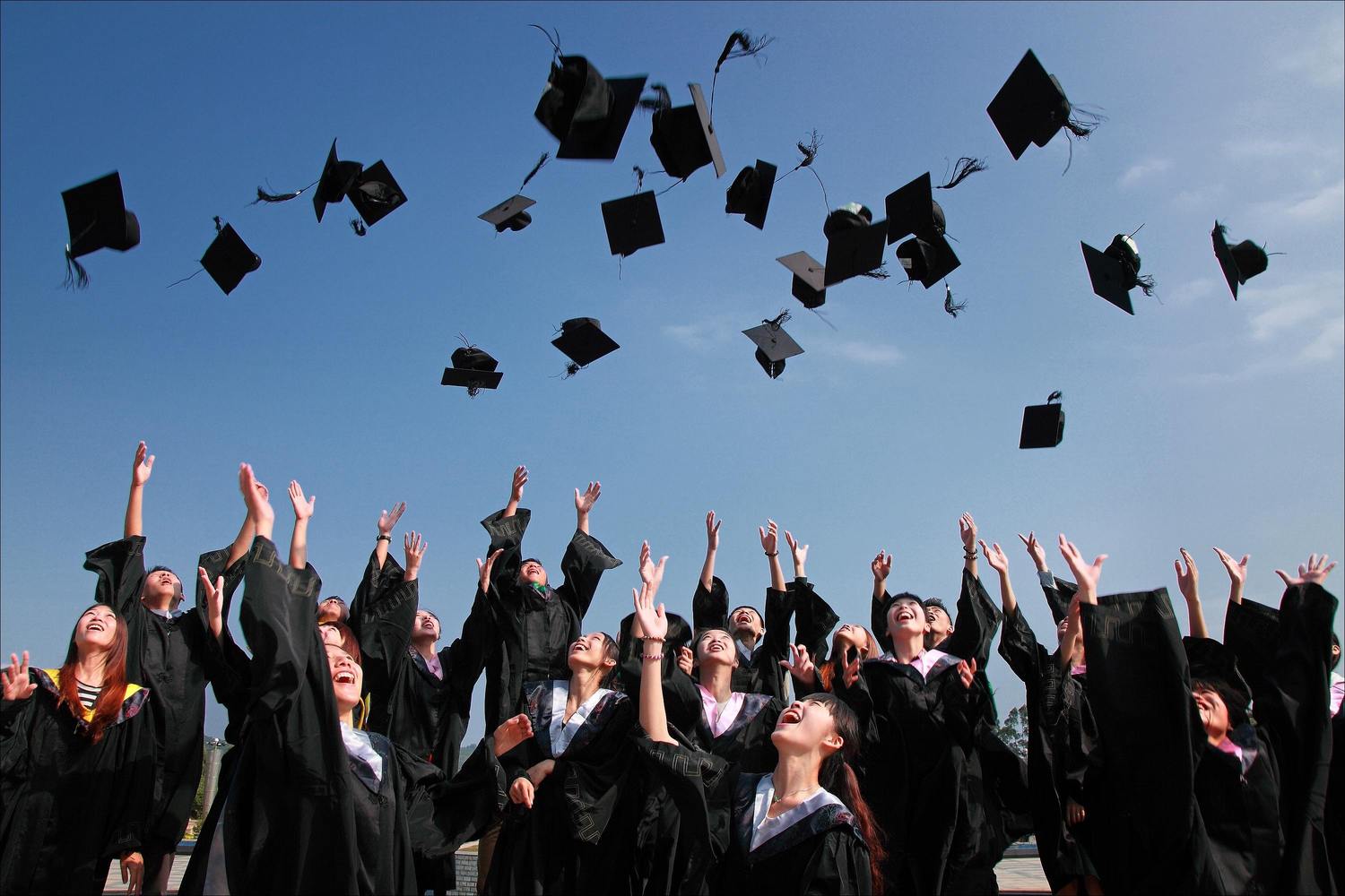 Viele Studenten werfen die Doktorhüte hoch