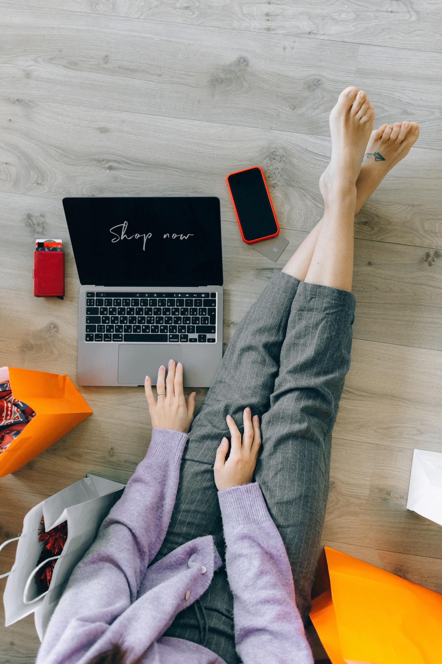 Person arbeitet am Laptop und sitzt auf dem Boden