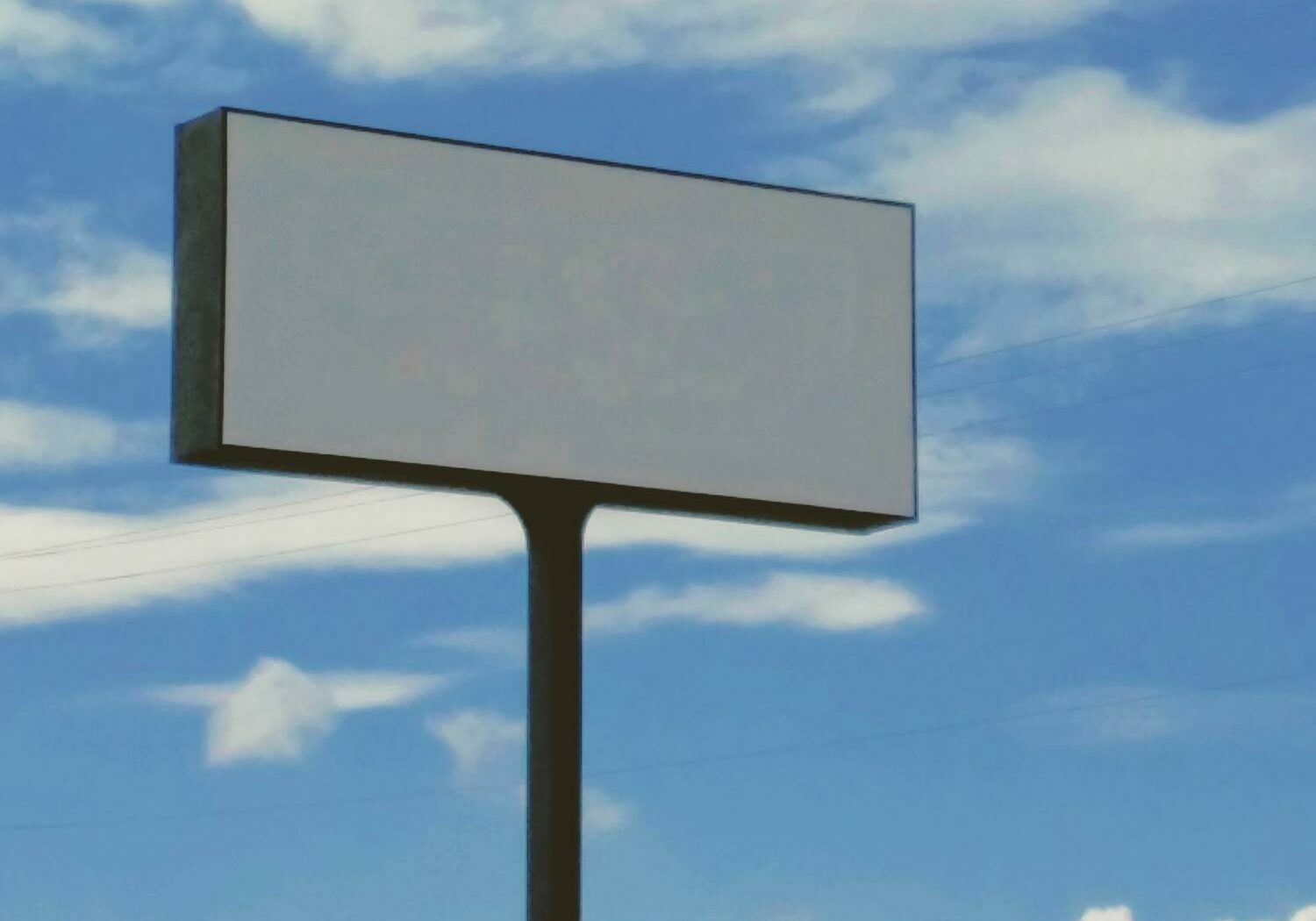 Leere Werbetafel vor blauem Himmel