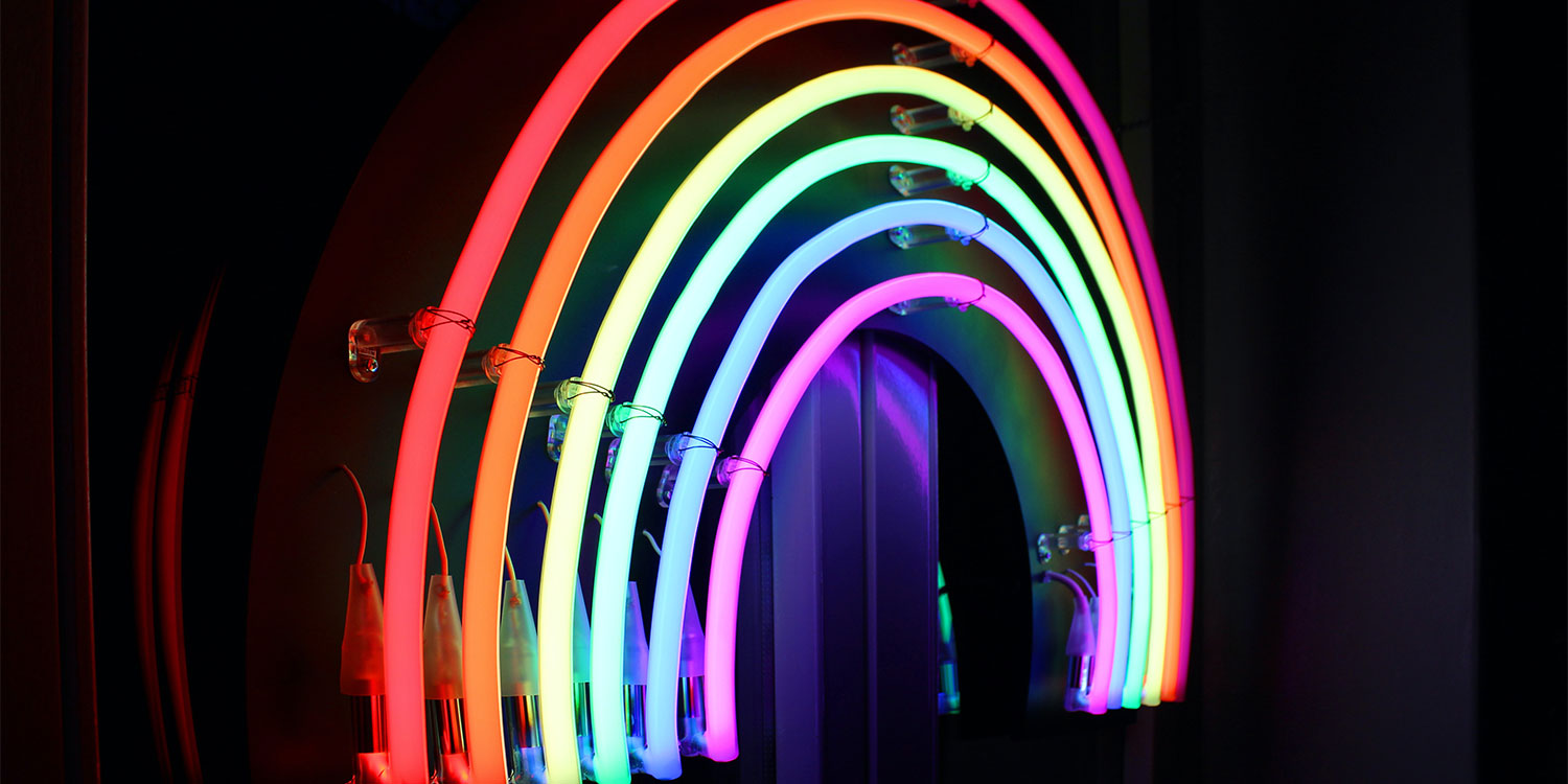 Leuchtender Regenbogenbogen bei Nacht.