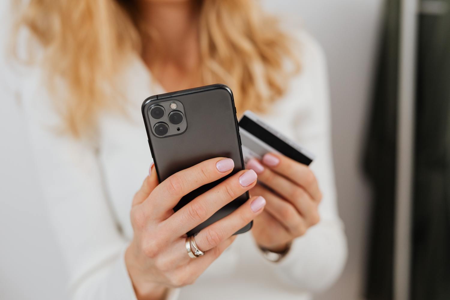 Pexels Karolina Grabowska 5717947 Scaled 1 Frau hält ein Smartphone und eine Kreditkarte.
