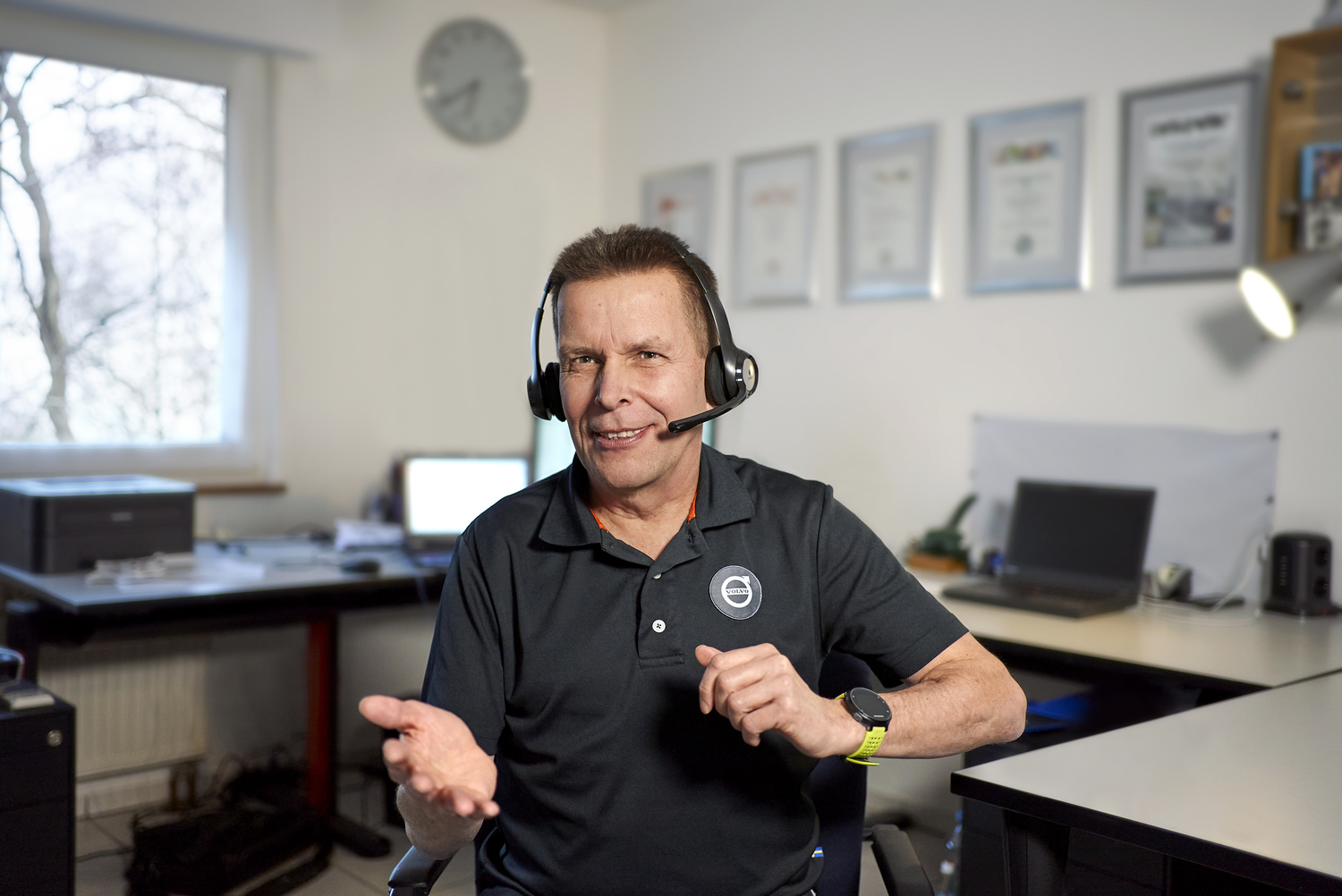 Mann mit Headset spricht in einem Büro.