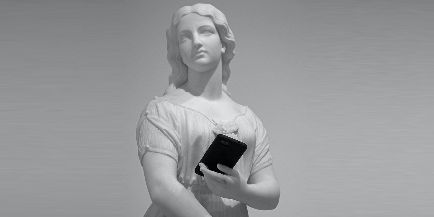 Statue hält ein Handy in der Hand.