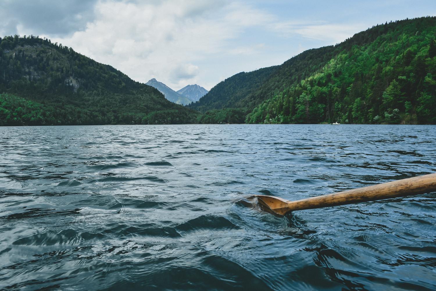 Ruderboot auf einem See zwischen Bergen.