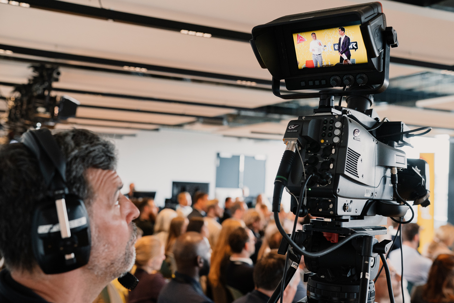 Kamera filmt eine Präsentation vor Publikum.