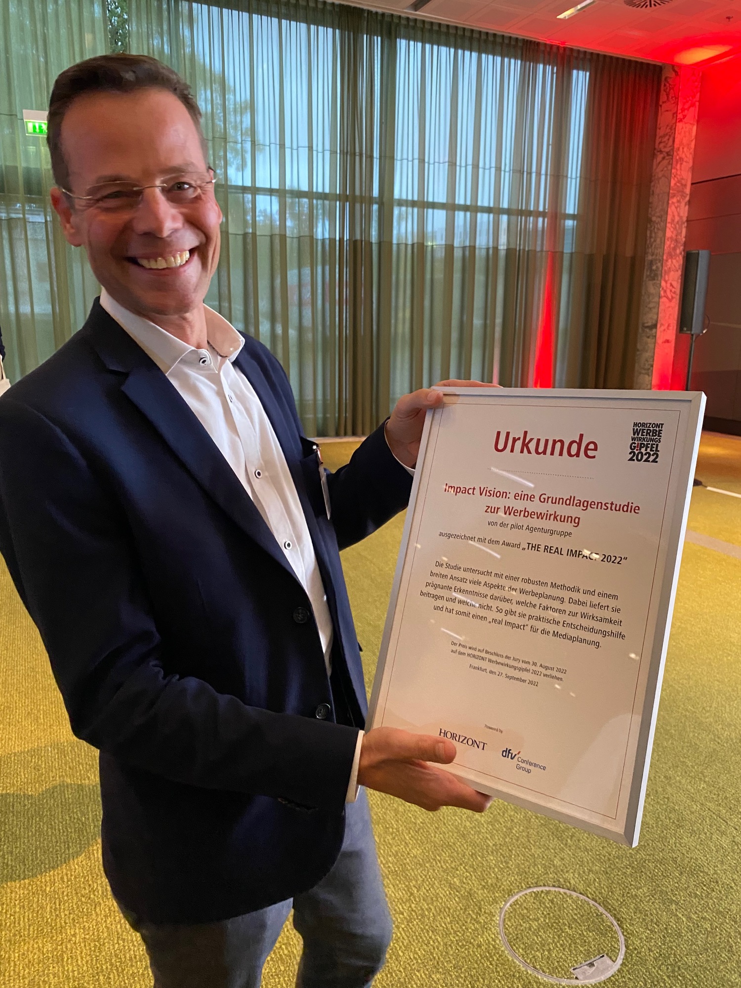 Lächelnder Mann hält eine Urkunde