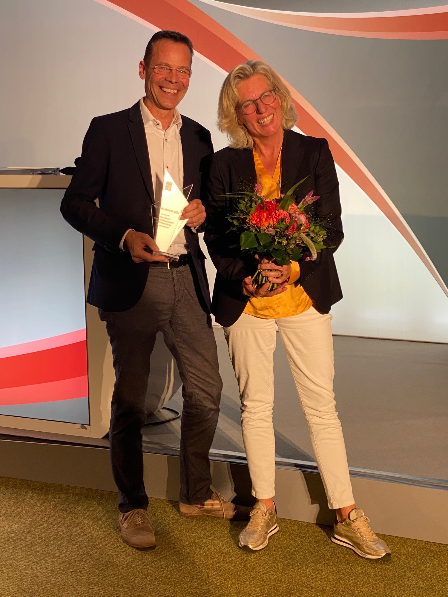 Zwei Personen mit The Real Impact Award