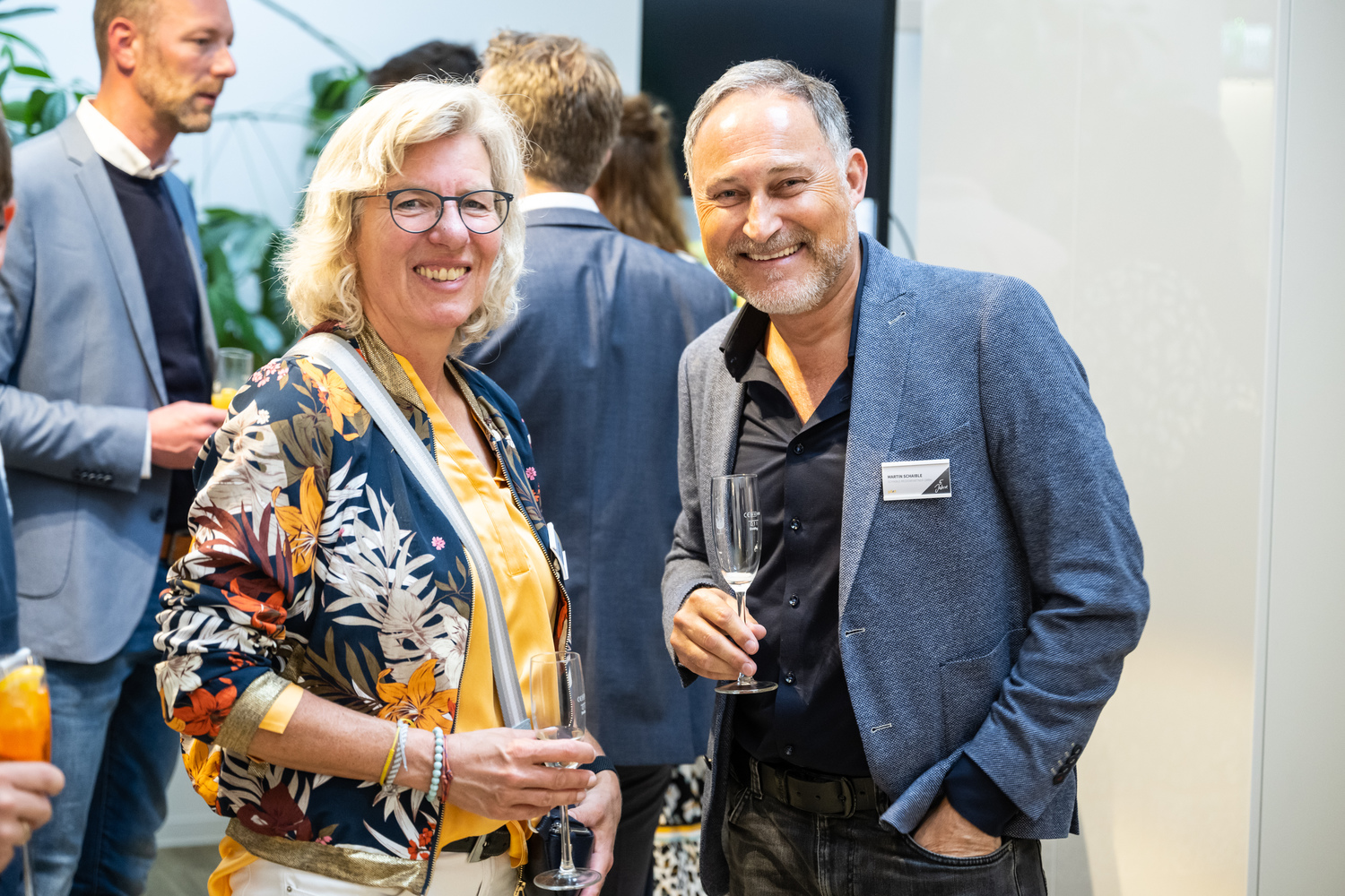 Lächelnde Frau mit Brille bei einem Networking-Event.