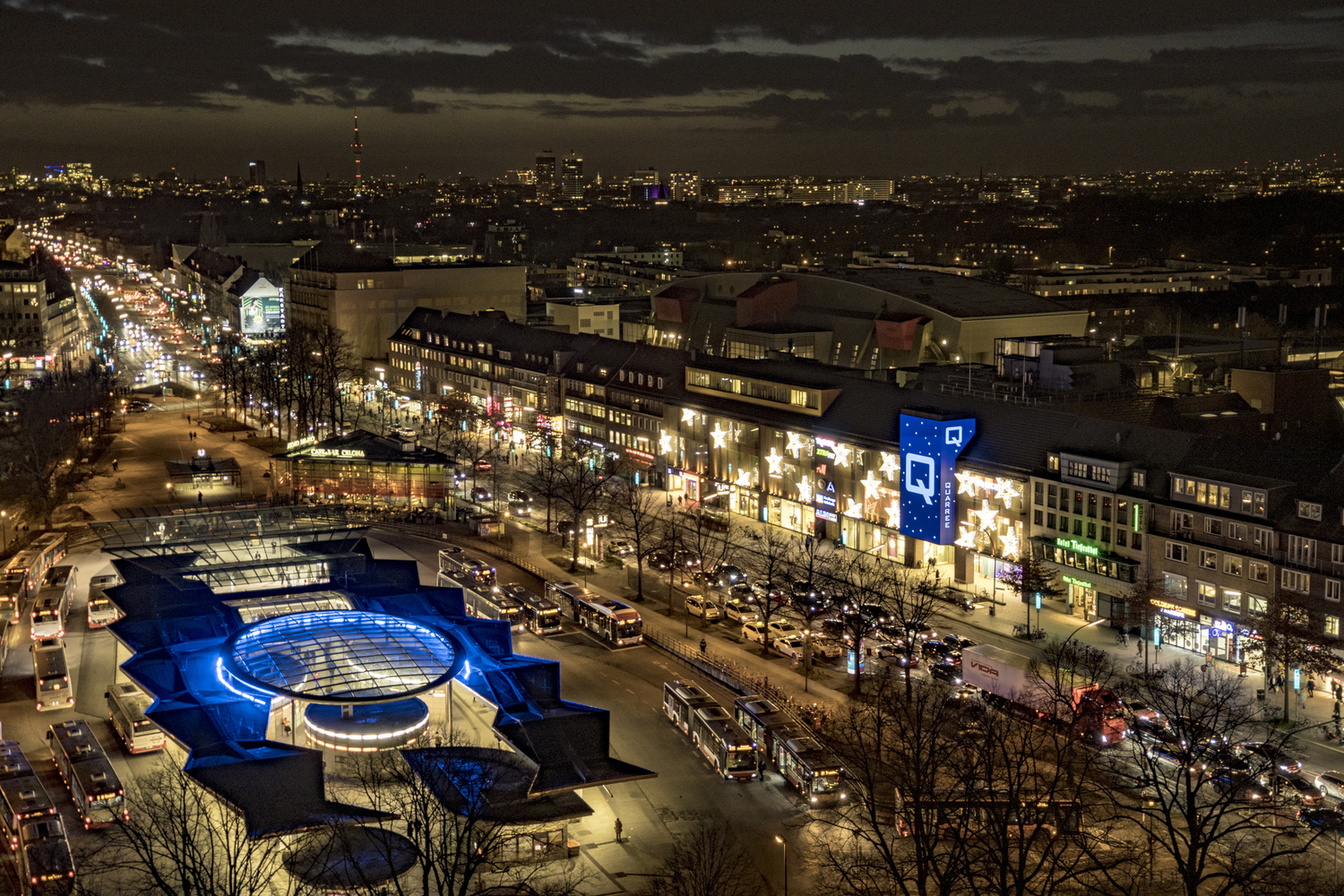 Nachtaufnahme eines beleuchteten Stadtgeländes.
