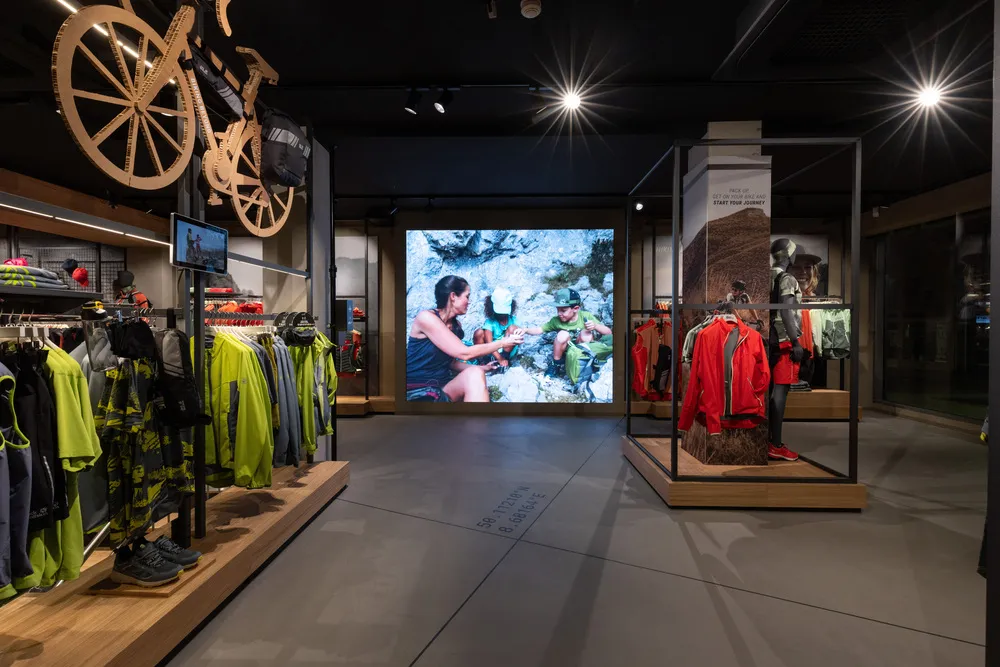 Shop mit Kleidung und großen Bildschirmen.