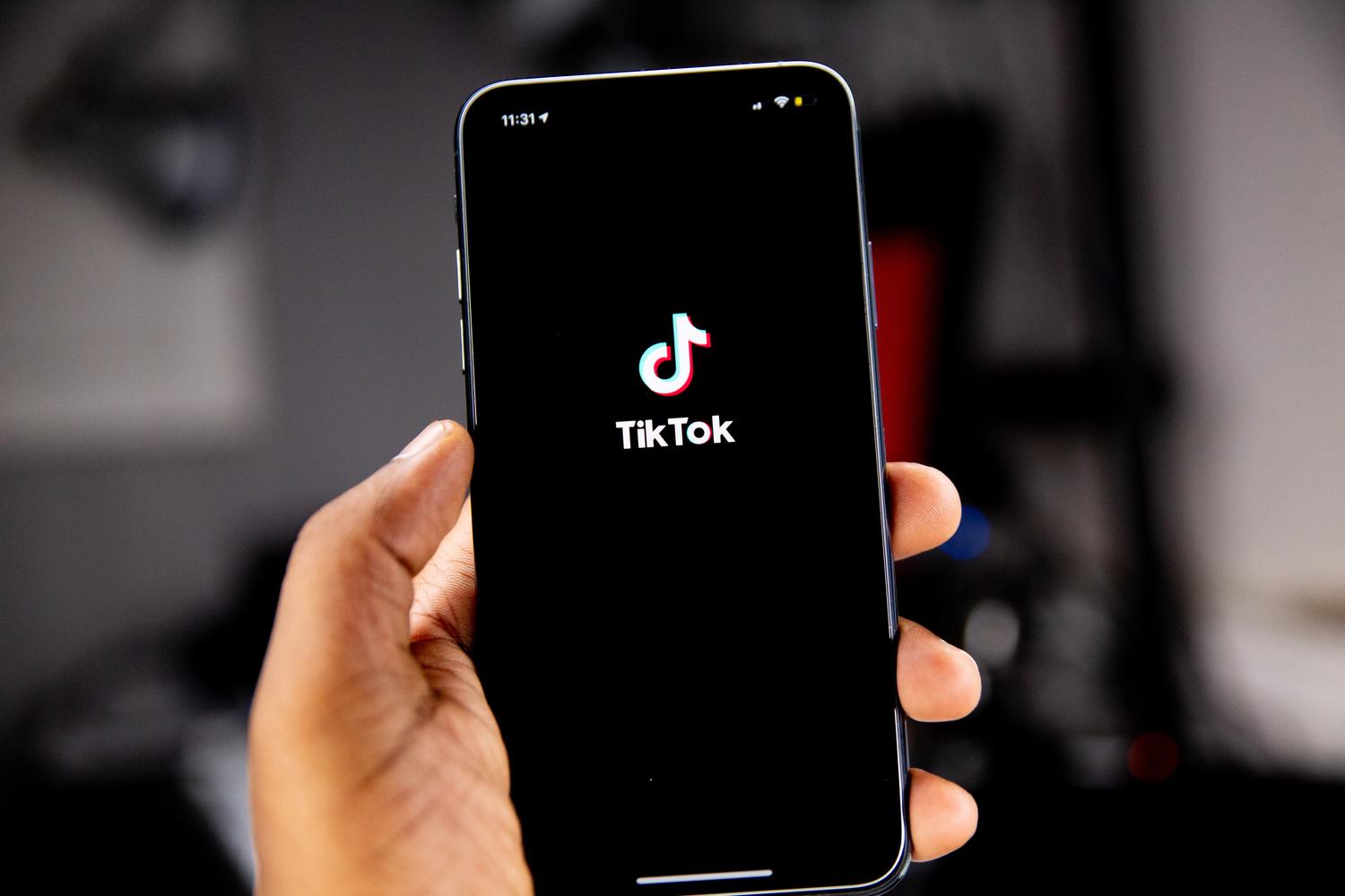 Hand hält ein Smartphone mit TikTok-Logo.