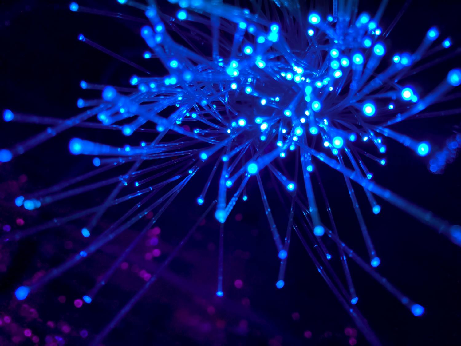 Blaue Lichtstrahlen vor dunklem Hintergrund.