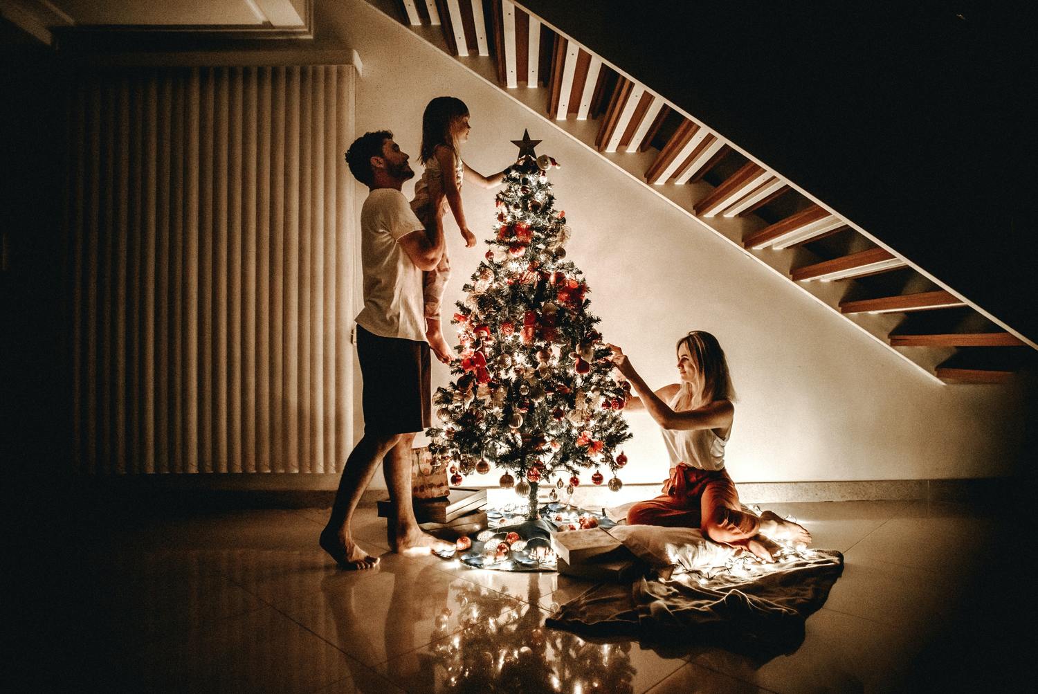 Familie schmückt einen Weihnachtsbaum.