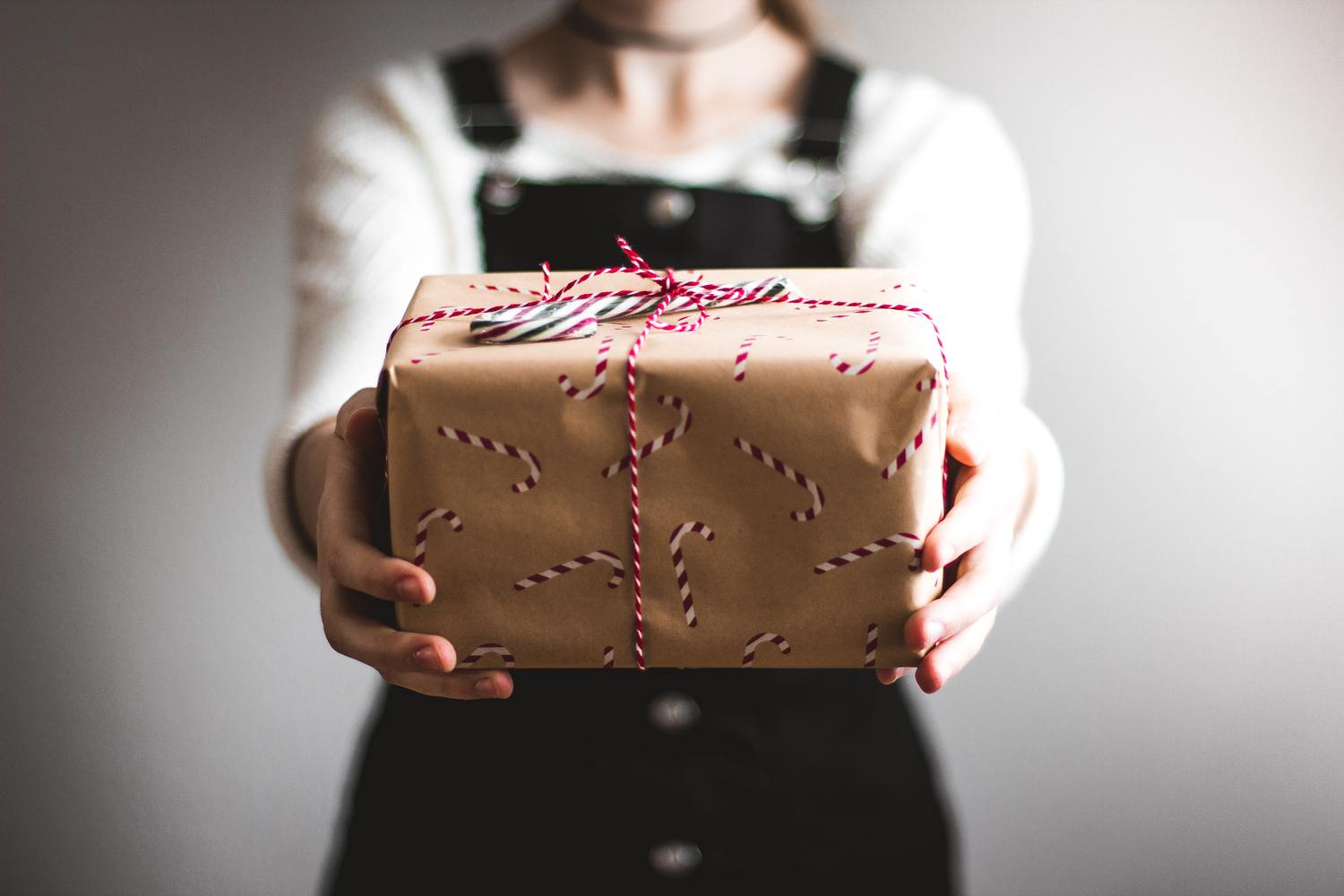 Person hält ein verpacktes Geschenk.
