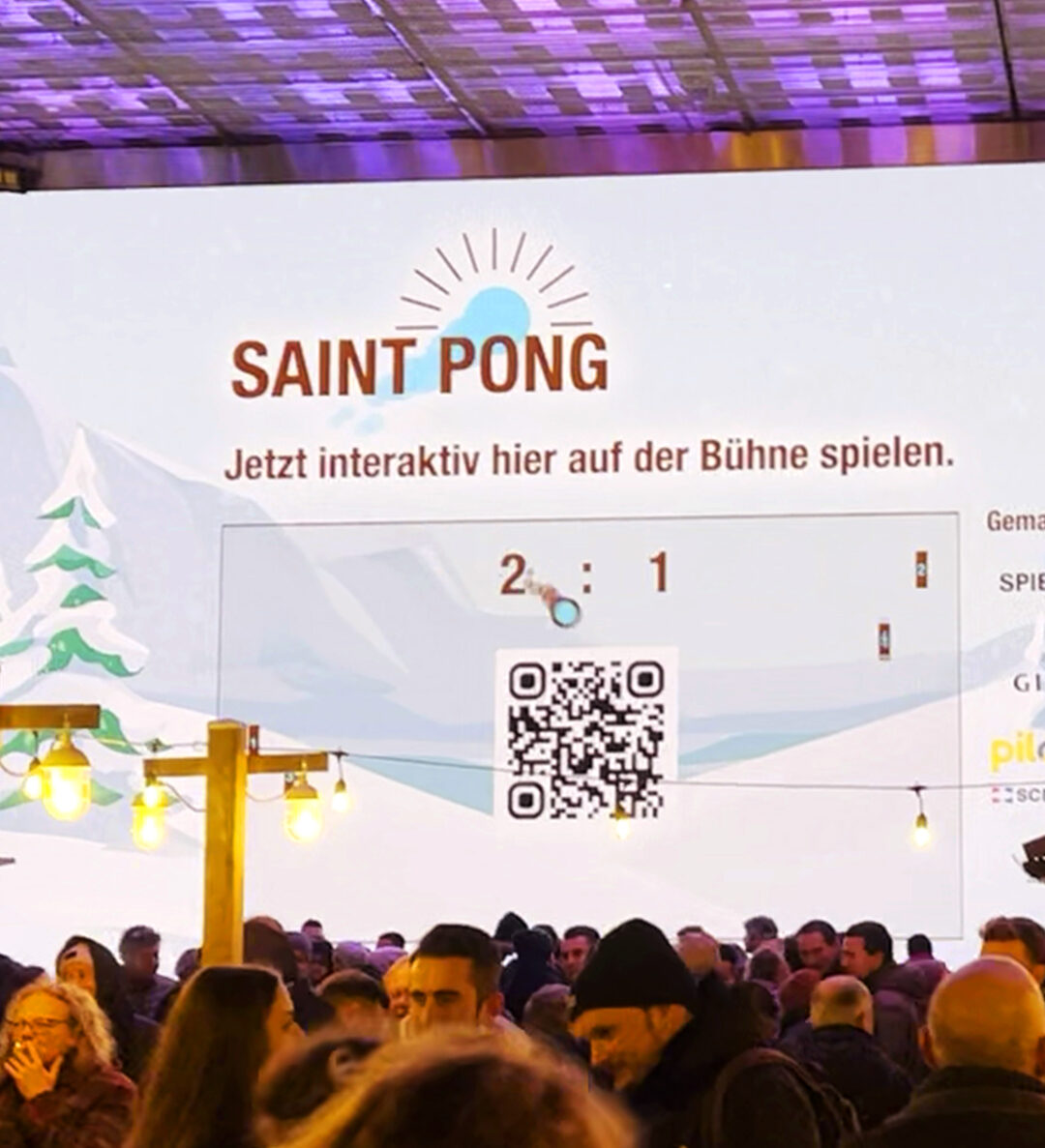 Menschenmenge bei einer Veranstaltung mit „SAINT PONG“-Anzeige.