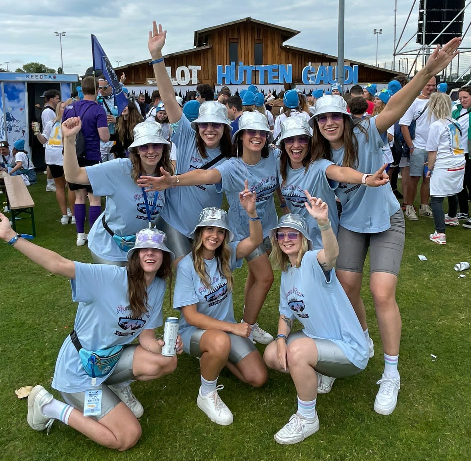 Eine Gruppe von Frauen trägt blaue Hemden und Hüte und posiert fröhlich für ein Foto.