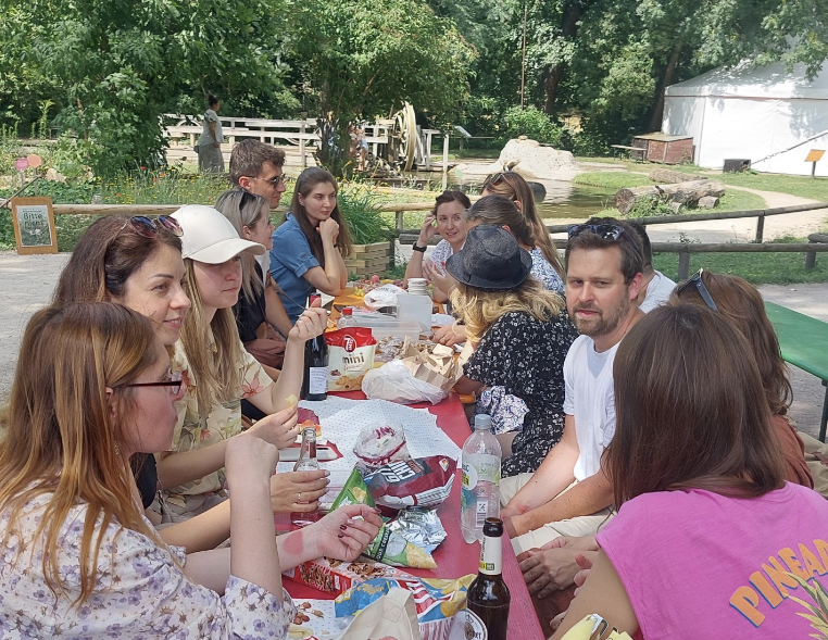 Eine Gruppe sitzen an einem Tisch und picknicken