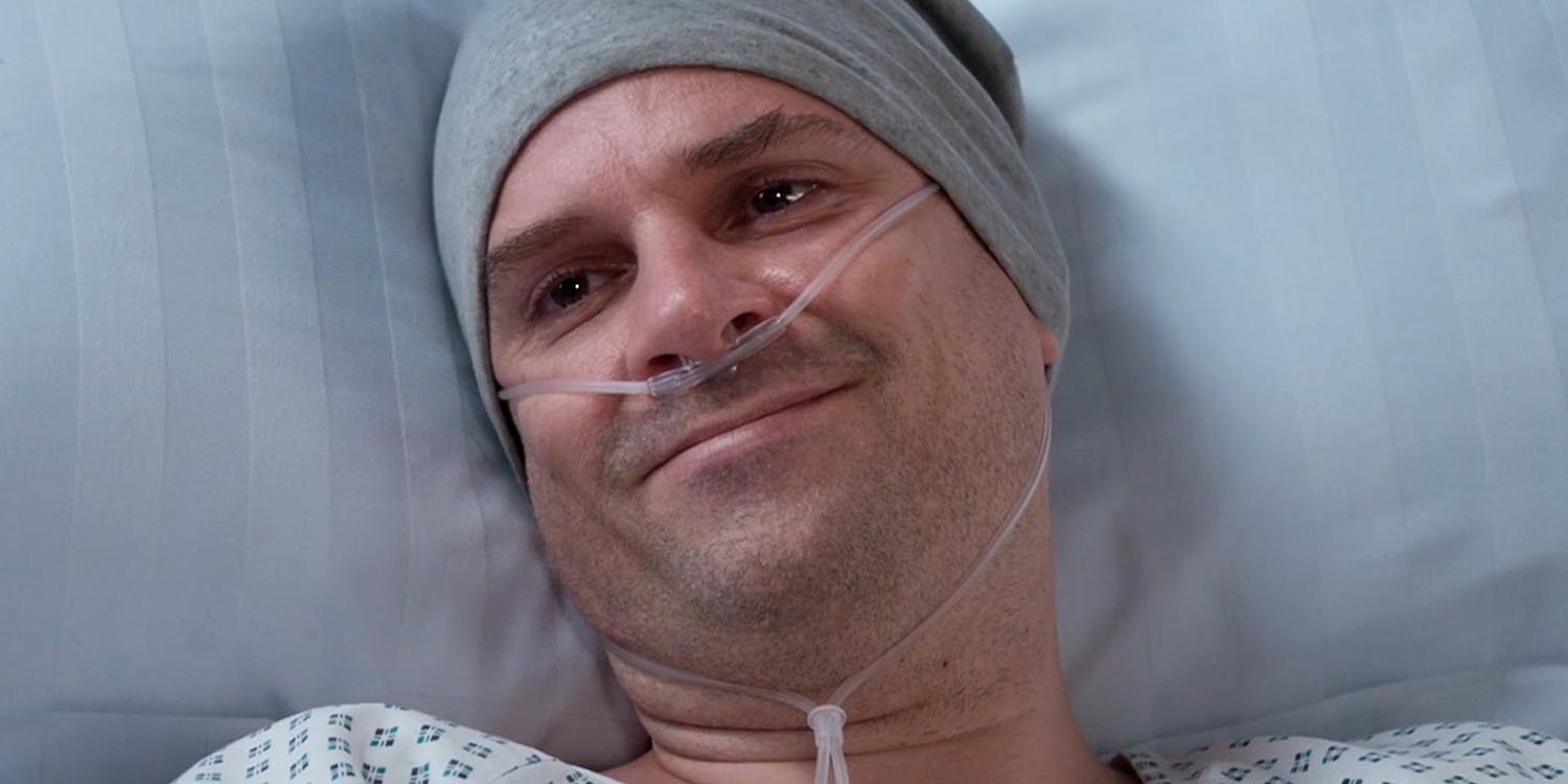 Ein Mann liegt im Krankenhausbett mit einem Tropf, der an seinem Kopf befestigt ist.