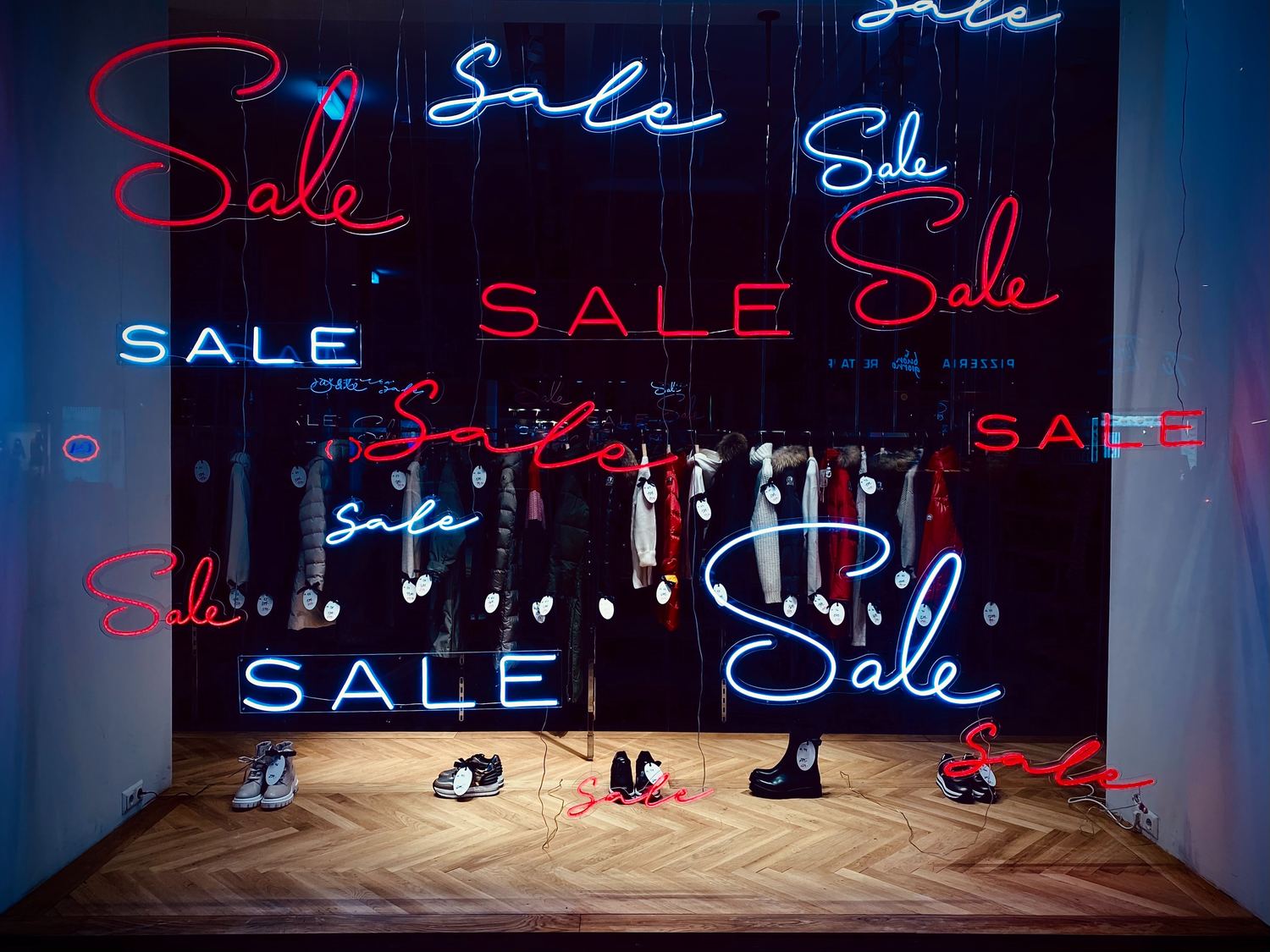Neon-Verkaufsschilder leuchten in einem Schaufenster.