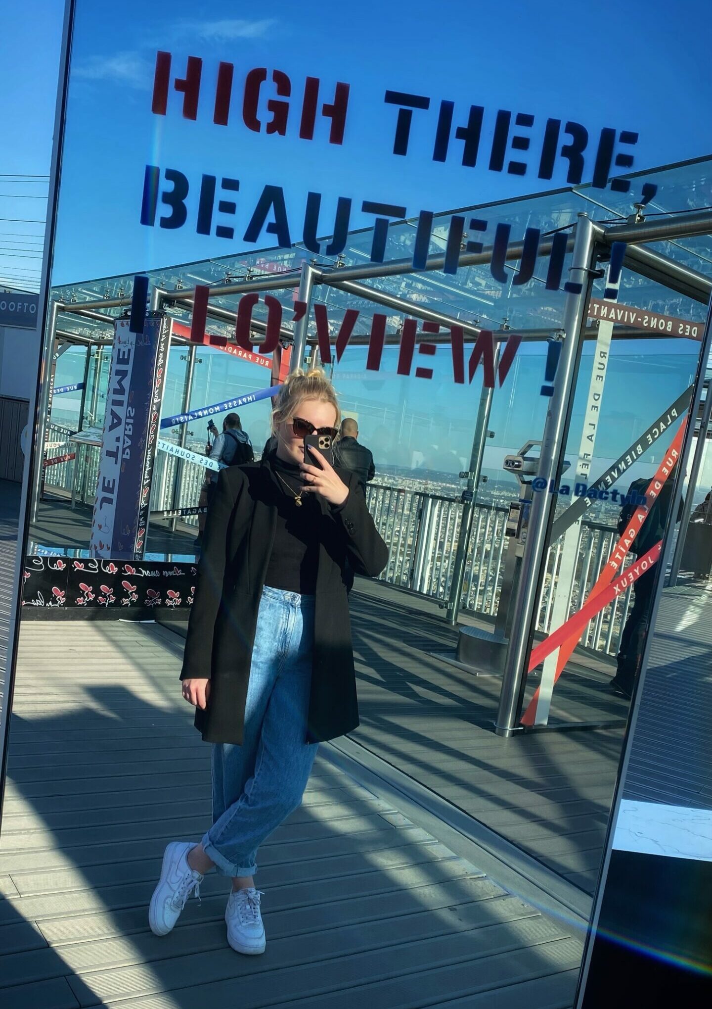 Eine Frau posiert vor einem Spiegel, während sie ein Selfie aufnimmt.