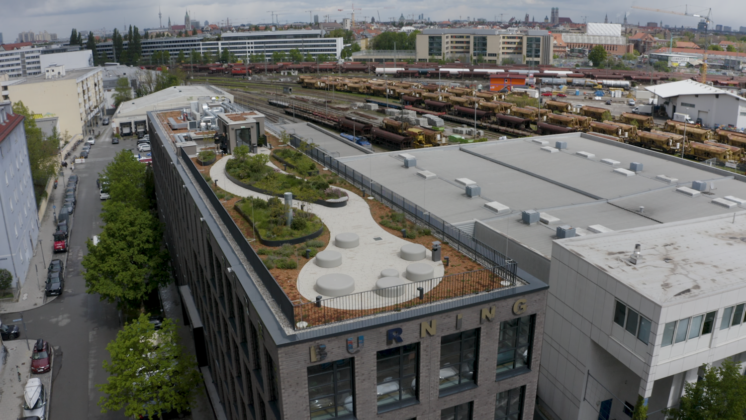 Eine Dachterrasse mit Pflanzen und Sitzmöglichkeiten auf einem Gebäude.