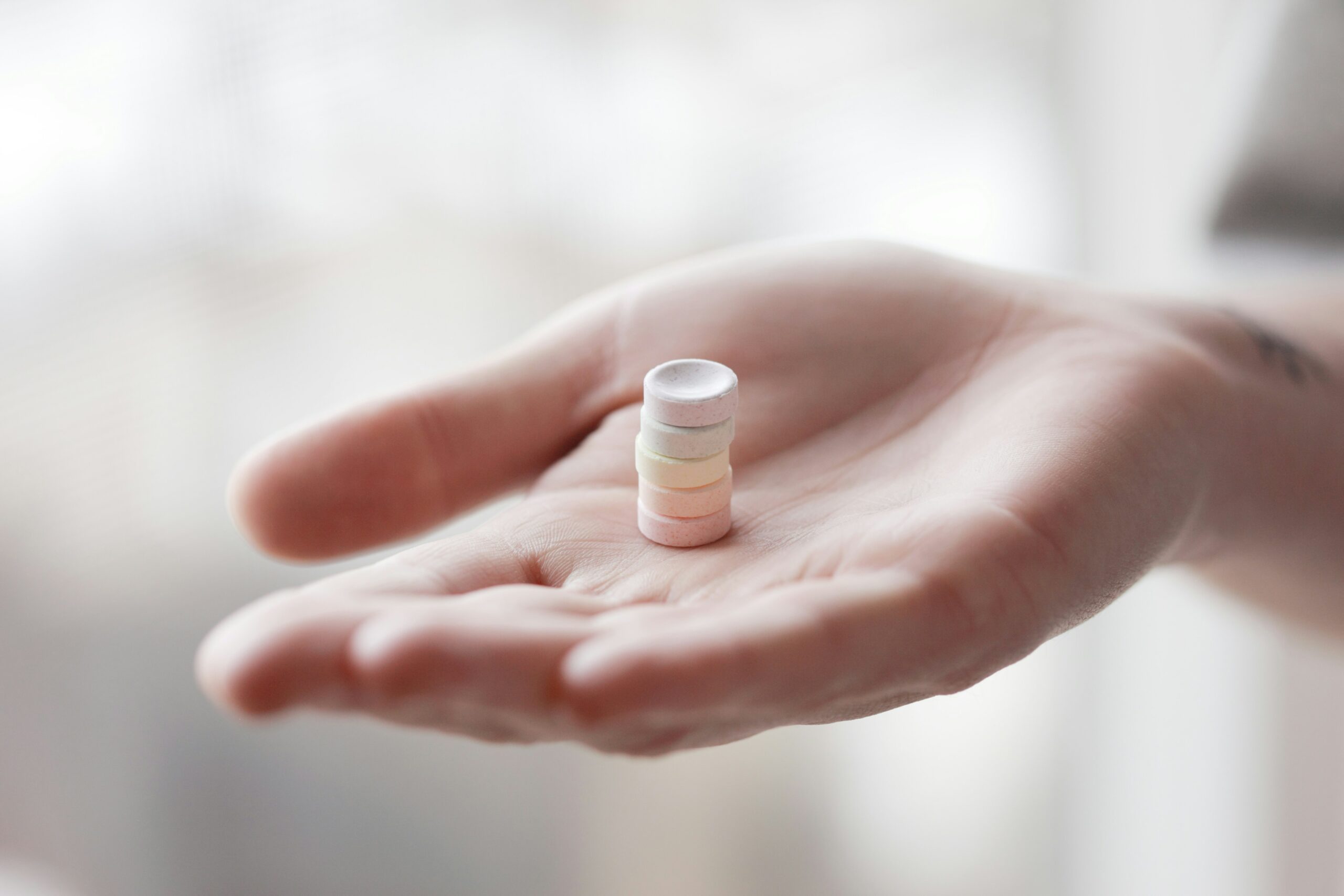 Alexander Grey Tr1po6kOWEc Unsplash Scaled Ein Stapel Tabletten auf einer Frauenhand