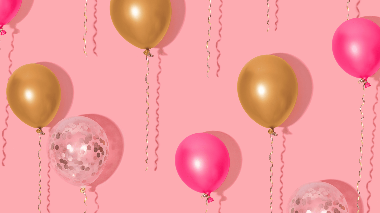 Goldene und pinke Luftballons auf rosa Hintergrund