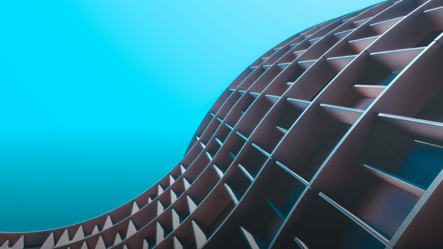 Ein geschwungenes Gebäude, von unten aufgenommen, vor blauem Himmel